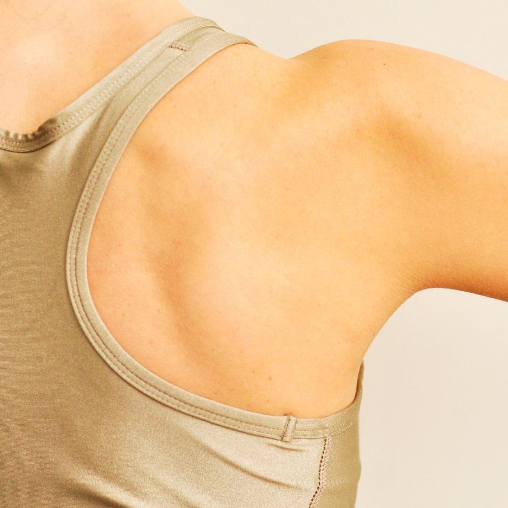 Photo of person's shoulder, wearing a brown tank top.